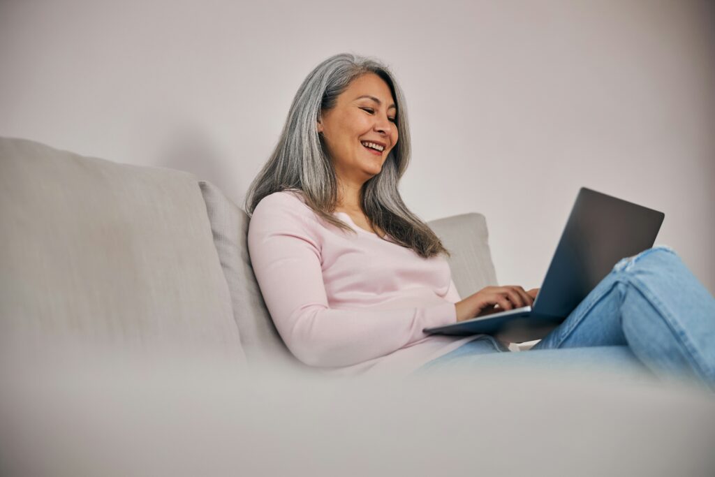 Middle aged woman with laptop and a happy expression on